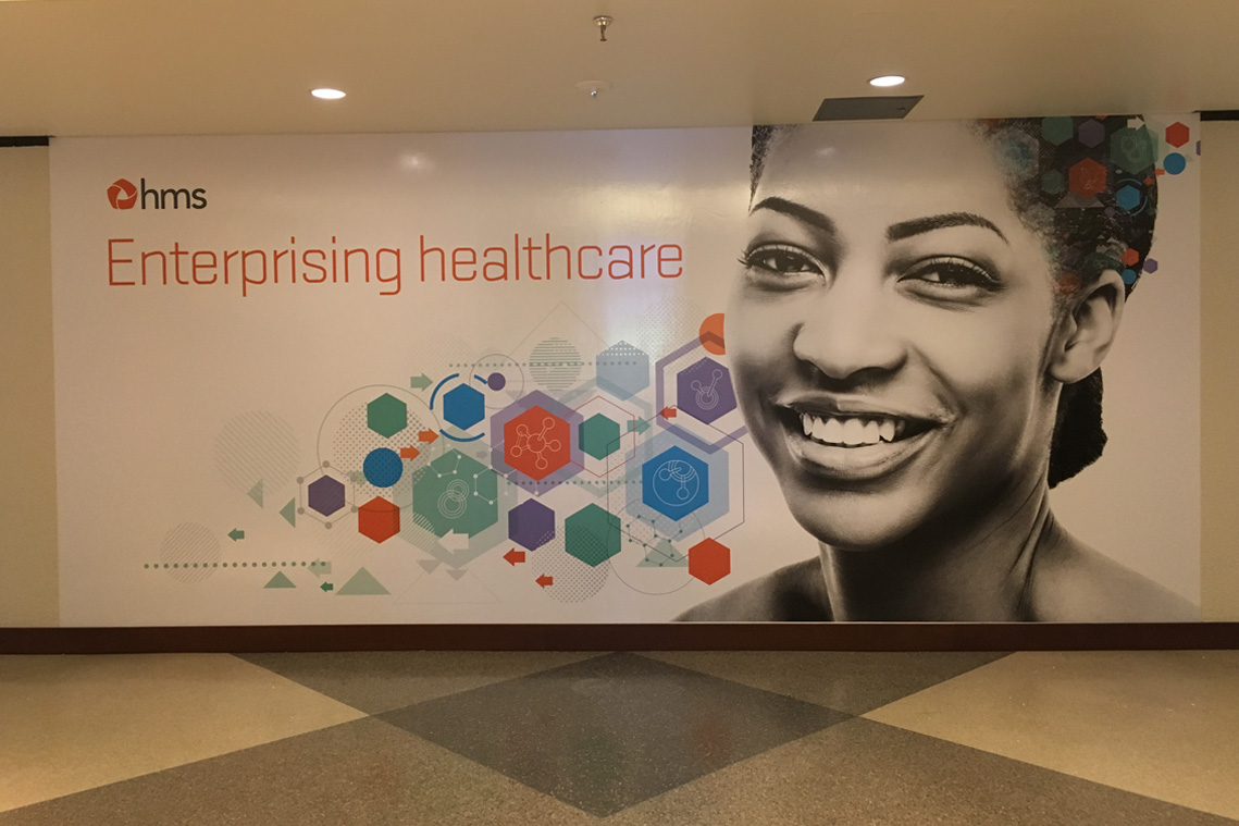Large lobby wall graphic featuring the new tagline Enterprising Healthcare