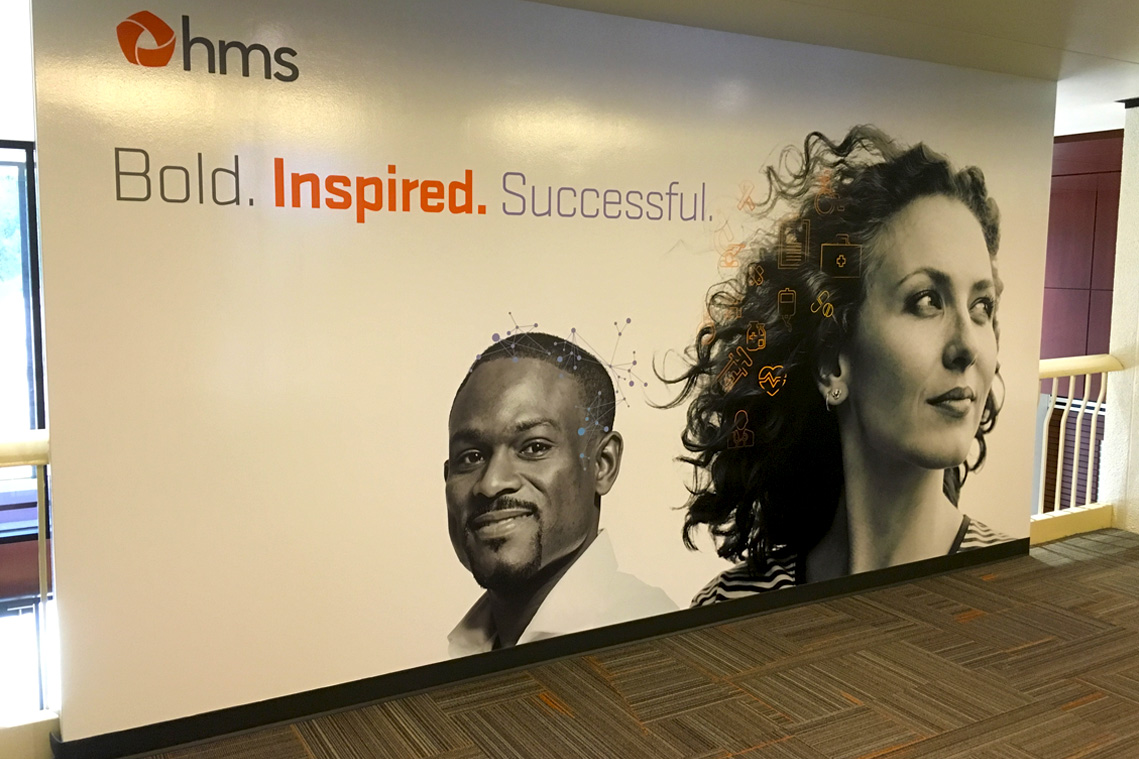 Large lobby wall graphic featuring the new brand descriptors - bold, inspired and successful